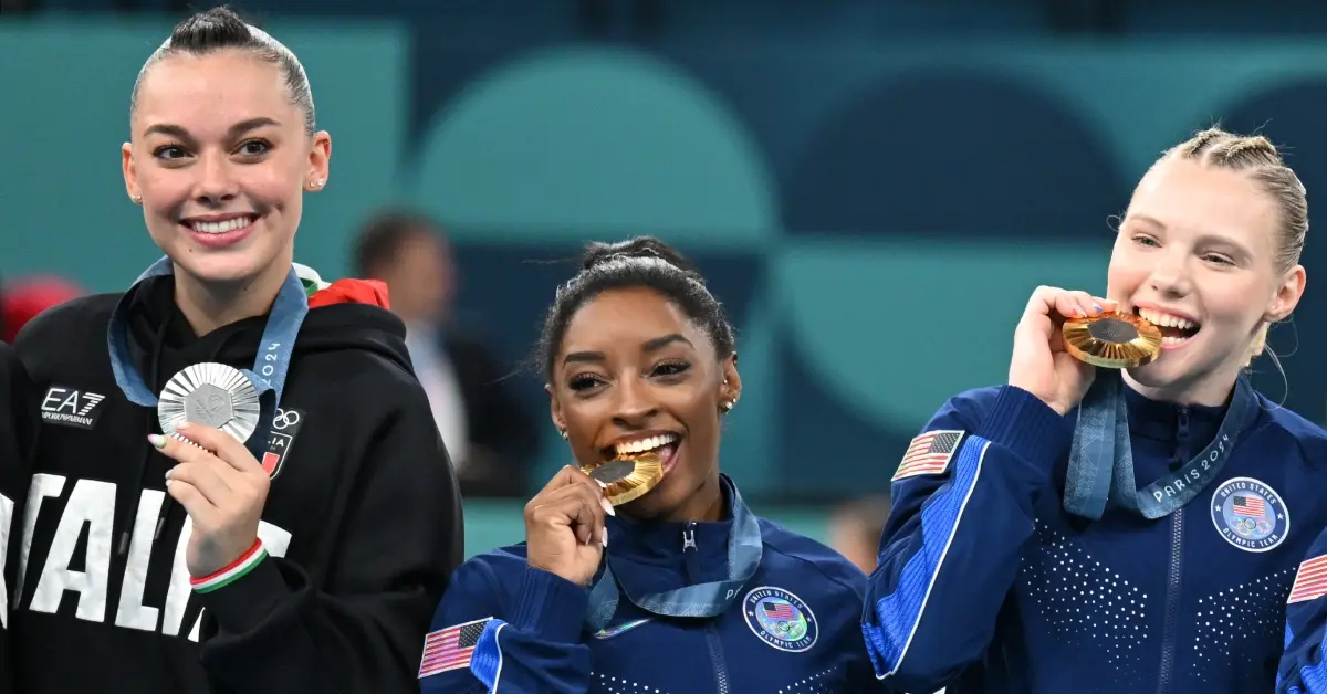 Three olympic female athletes biting their medals.